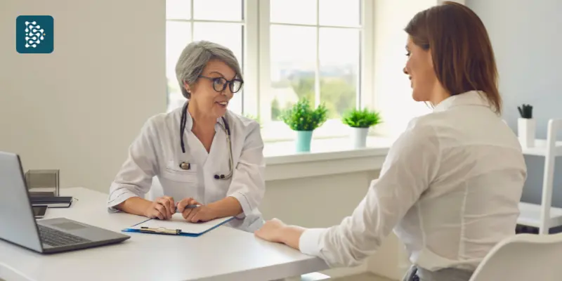 médica com informações do paciente atendendo mulher