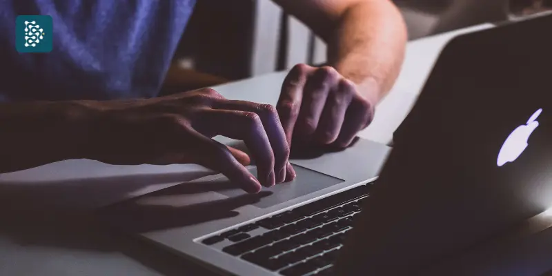 homem usando notebook em  ambiente a meia luz