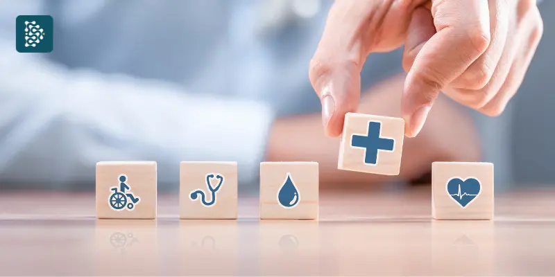 mão segurando dados de brinquedo com símbolos médicos representando ciclo pdca