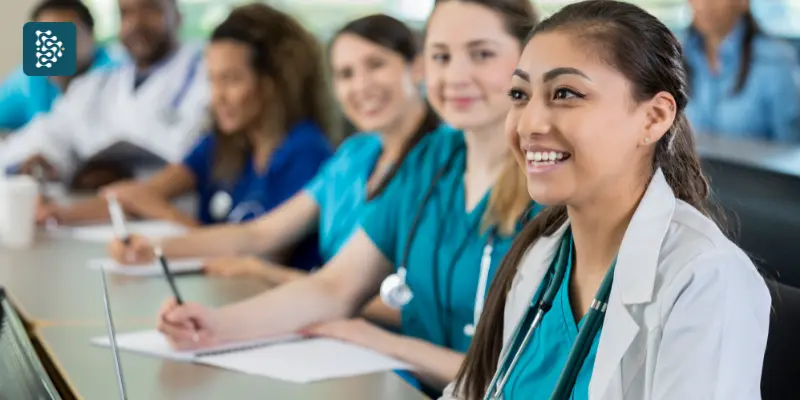 Médica asiática sorrindo durante palestra em congresso médico.