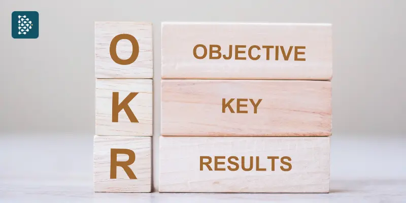 dados de madeira clara com letras do método OKR gravadas