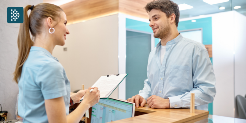 recepcionista de clínica médica conversando paciente na recepção hospitalar
