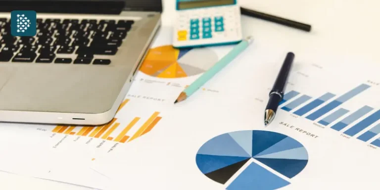 notebook ao lado de planilhas de gestão financeira