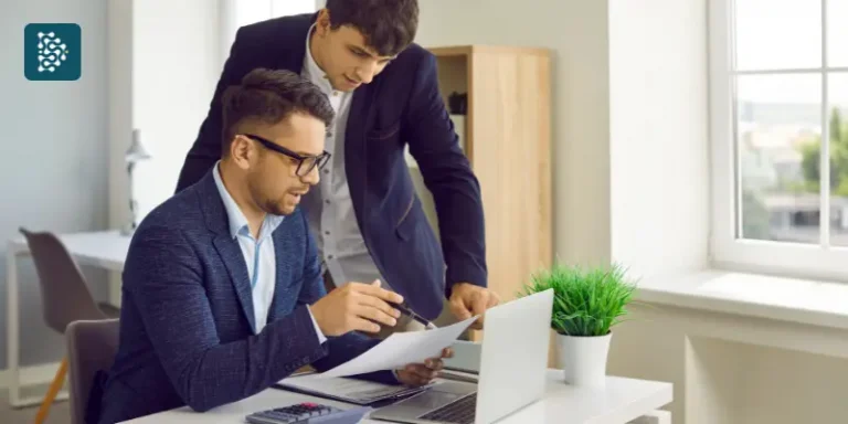 dois homens jovens checando informações financeiras no traballho