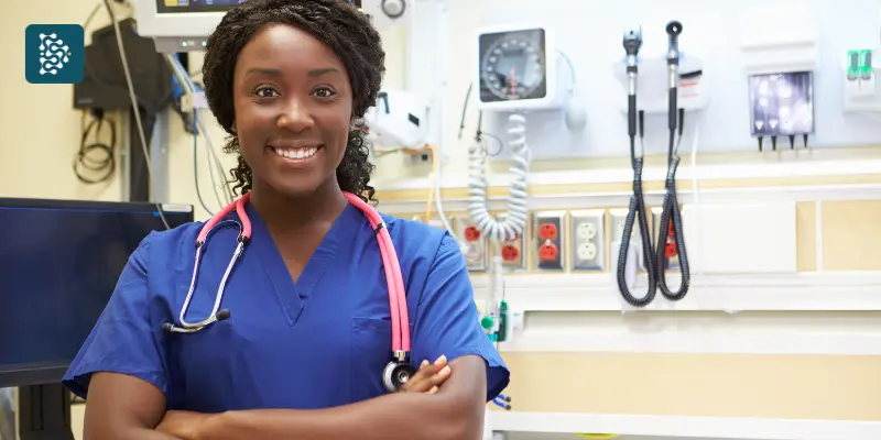 Enfermeira negra sorrindo ao lado de equipamentos hospitalares, imagem que representa a humanização e a gestão de hospitais com o sistema Datasigh.