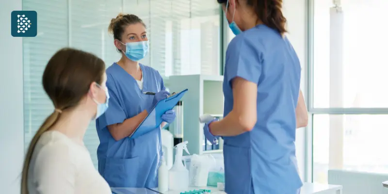 enfermeiras aplicando medicação em uma paciente