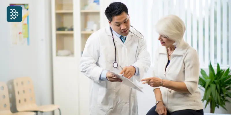 médico no consultório dando atenção a idosa  para fidelização e pós-venda