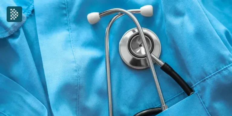 Estetoscópio médico repousa sobre um uniforme de hospital azul, simbolizando Excelência Organizacional no setor de saúde. A imagem transmite profissionalismo, cuidado e eficiência na área médica.