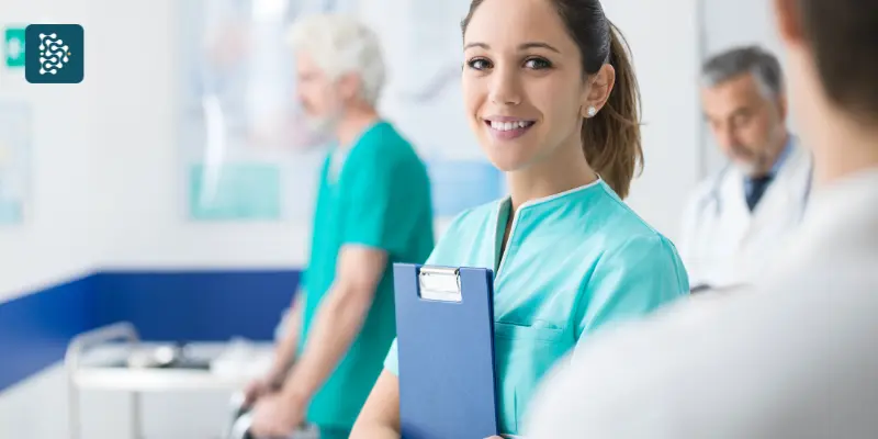 Funcionária de hospital sorrindo com prancheta de certificado, representando atendimento e qualidade hospitalar.