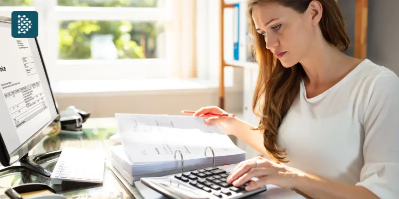 Gestão de Faturamento - mulher loira fazendo contas em uma calculadora