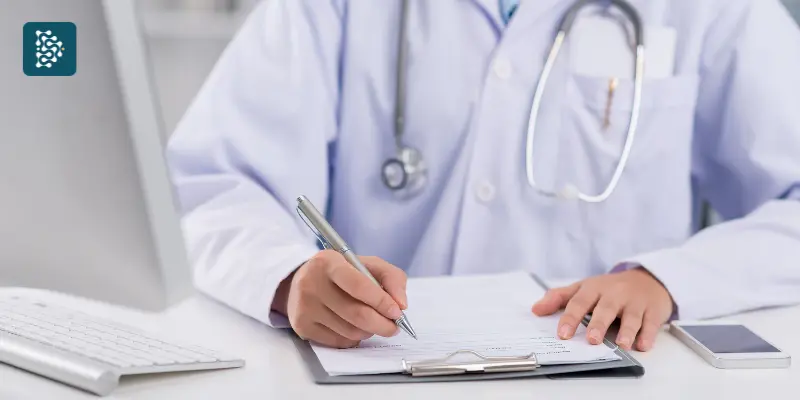 médico fazendo anotações do prontuário de um paciente