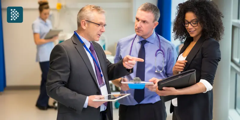 diretores de hospital conversando no corredor sobre a RN 518