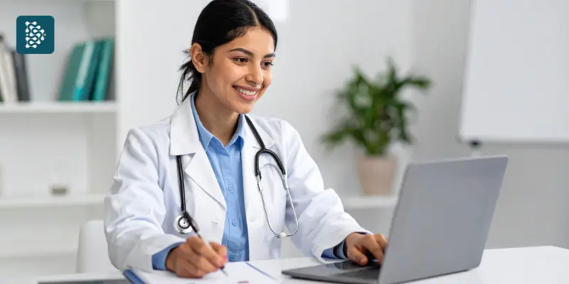 Médica utilizando computador para organizar processos da clínica, representando a gestão eficiente com o sistema Datasigh.