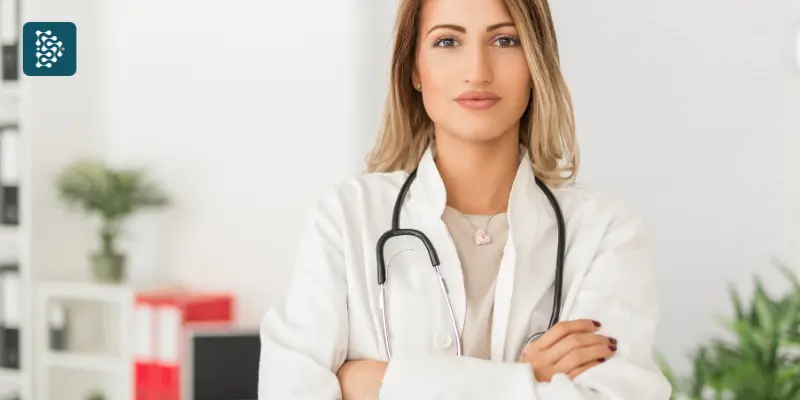 Médica de braços cruzados representando confiança e liderança na medicina preditiva e na gestão em saúde com o sistema hospitalar Datasigh.