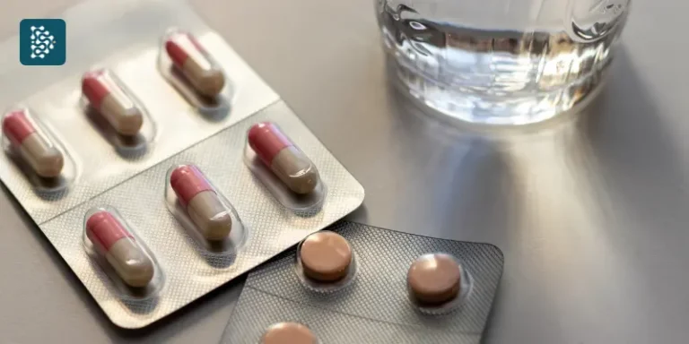 duas drágeas de medicamentos controlados ao lado de um copo d'água após compra com receita digital