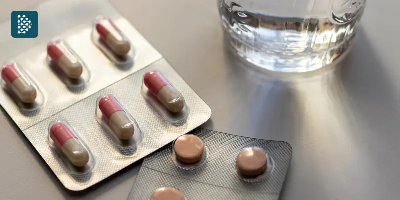 duas drágeas de medicamentos controlados ao lado de um copo d'água após compra com receita digital