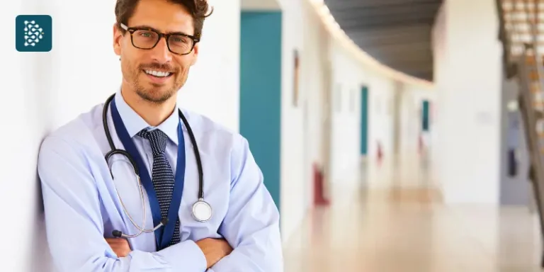 Médico empreendedor encostado na parede do corredor do hospital, segurando estetoscópio.