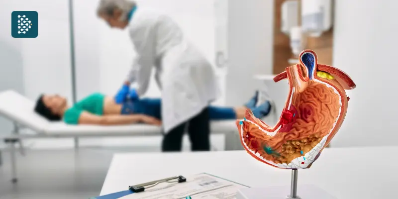 Médica examinando estômago de paciente deitada em maca durante atendimento em gastroenterologia. 