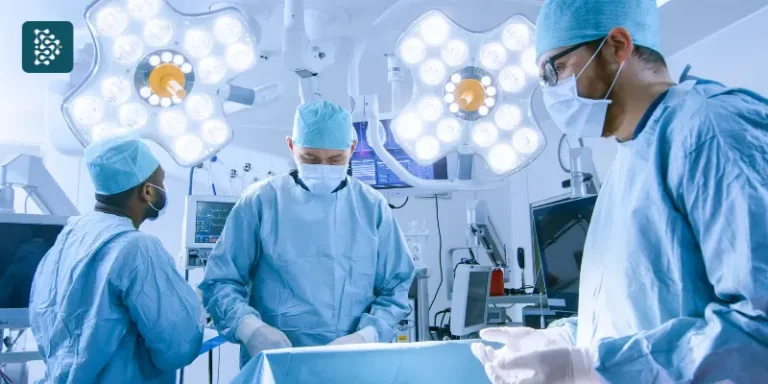 Equipe médica em centro cirúrgico sob luzes de operação, realizando procedimento com segurança.
