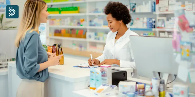 Farmacêutica atendendo uma paciente no balcão da farmácia, conferindo prescrição digital de receita médica usando Mevo e Datasigh.