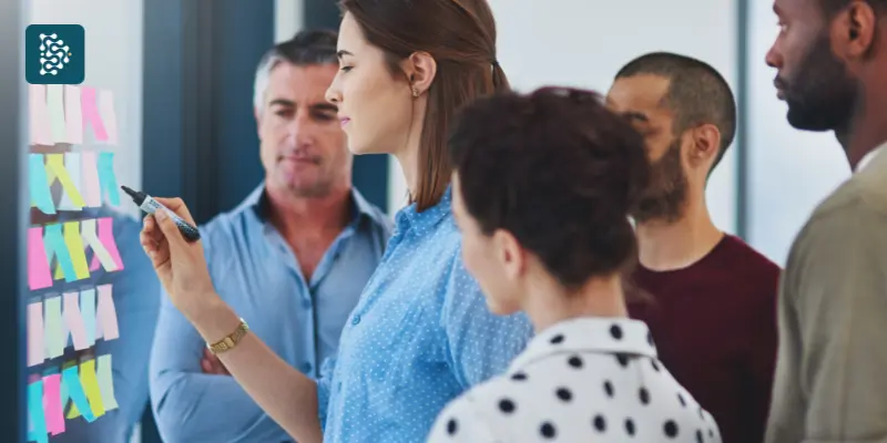 pessoas em treinamento fazendo anotações em post-it