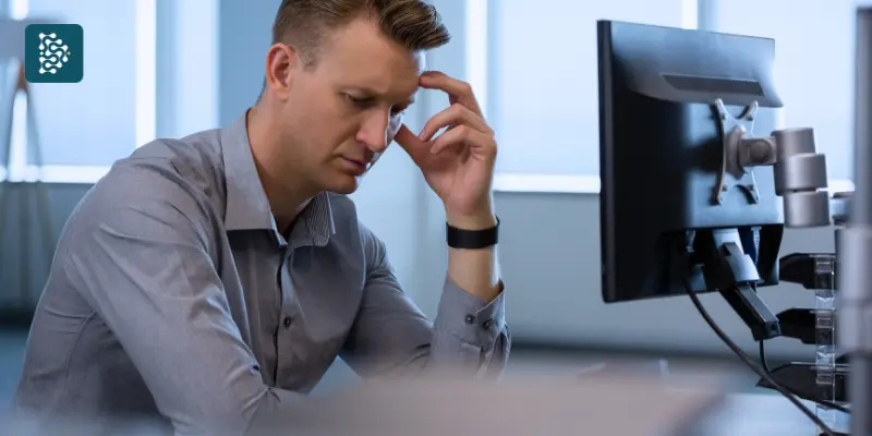 Homem executivo com expressão de preocupação diante do computador utilizando sistema Datasigh.