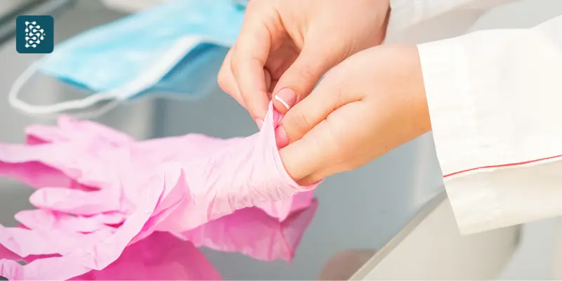 médica da mulher colocando luva cor de rosa