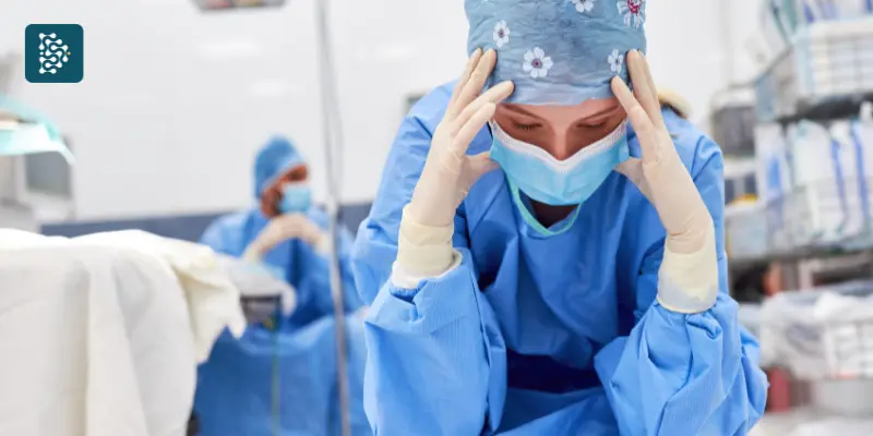 enfermeira exausta com as mãos na cabeça reflexo da rotatividade e turnover em Clínicas Médicas