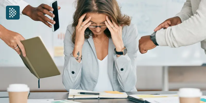 mulher com problema de saúde mental recebendo dos colegas muitas demandas de trabalho