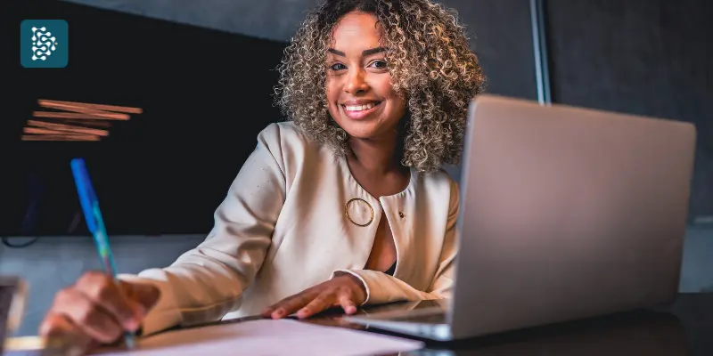 mulher jovem negra sorrindo no trabalho por estar com saude mental em dia