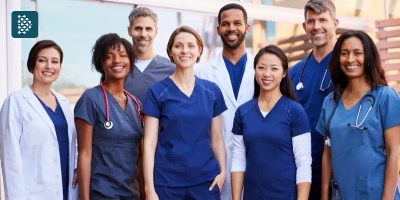 Equipe hospitalar diversa e unida posando para foto com sorrisos