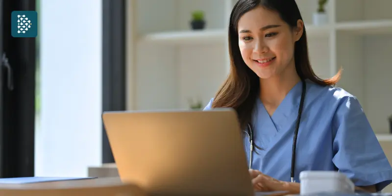 Jovem médica utilizando o sistema de gestão hospitalar Datasigh EMR/PEP para consultar e atualizar prontuário eletrônico no computador.