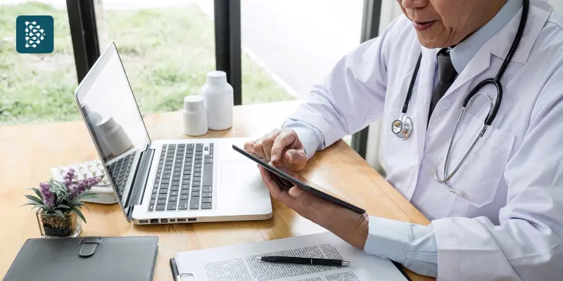 médico usando notebook para analisar métricas e indicadores