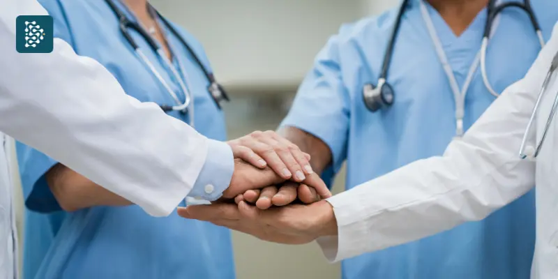 Equipe médica com as mãos unidas, simbolizando colaboração e trabalho em equipe na gestão hospitalar, com o logo da Datasigh no canto superior esquerdo.