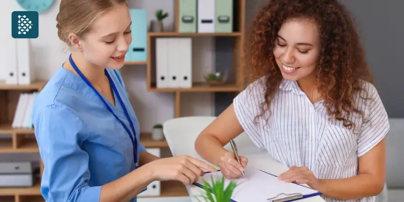Sistema de gestão hospitalar Datasigh aplicado ao controle de no-show de pacientes e faltas em consultas, com mulher assinando papéis na recepção de clínica médica, foco em Lifetime Value na saúde.